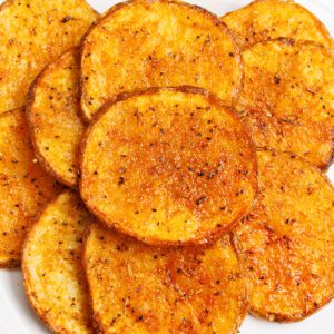 Overlapping oven baked potato slices on a white plate.