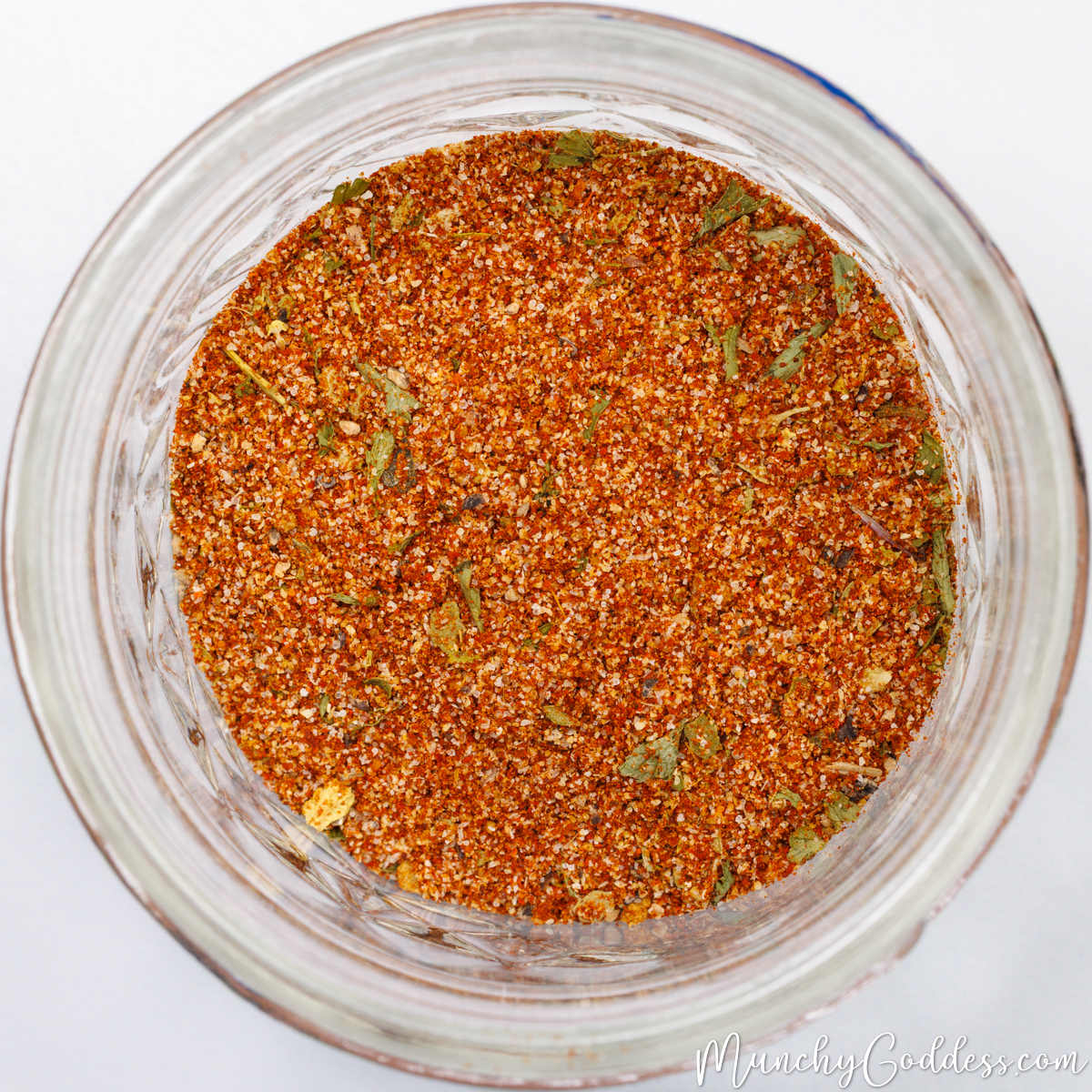 Overhead look into a circular glass jar filled with homemade taco seasoning.