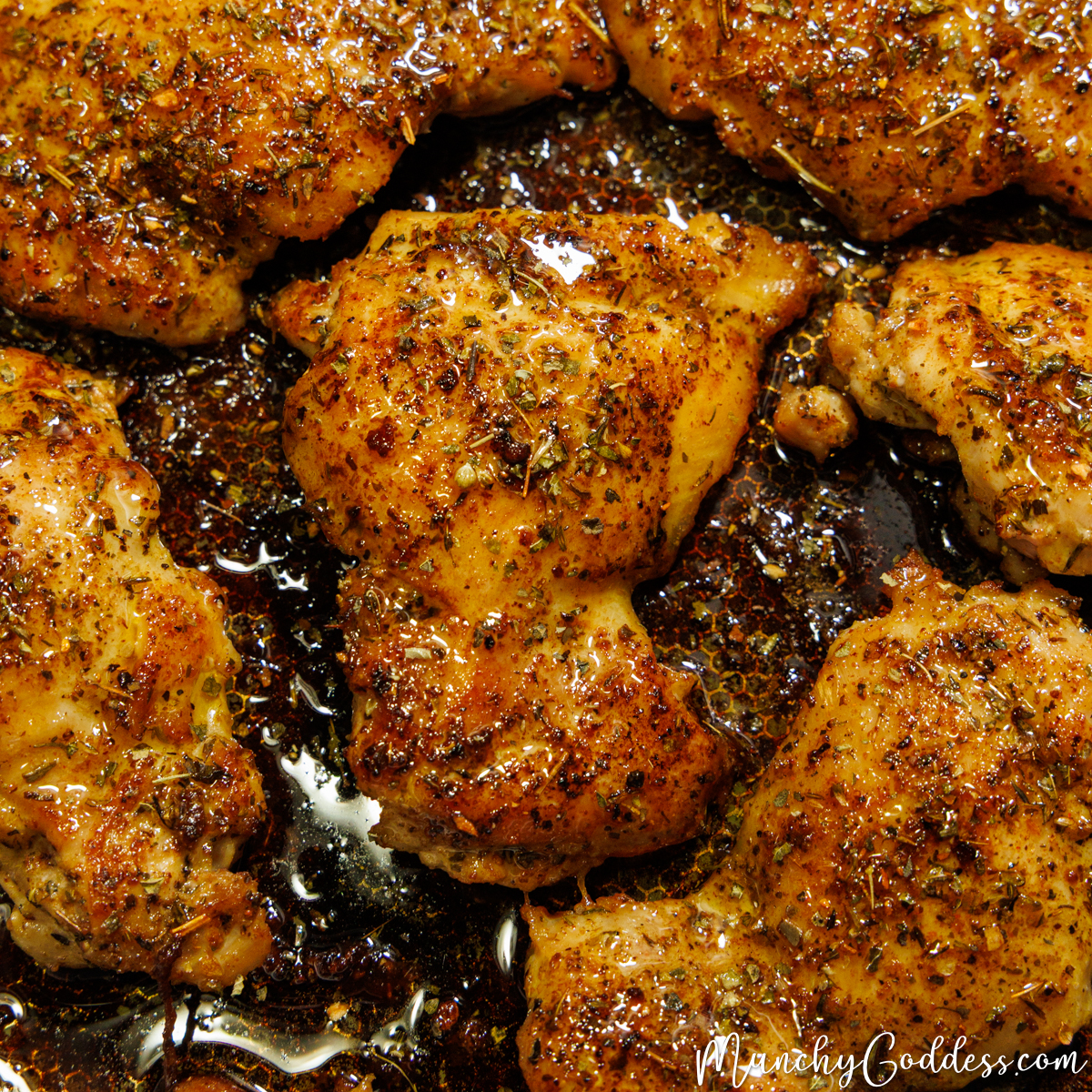 Cajun butter chicken thighs in a skillet with butter sauce.