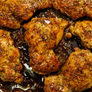 Cajun butter chicken thighs in a skillet with butter sauce.