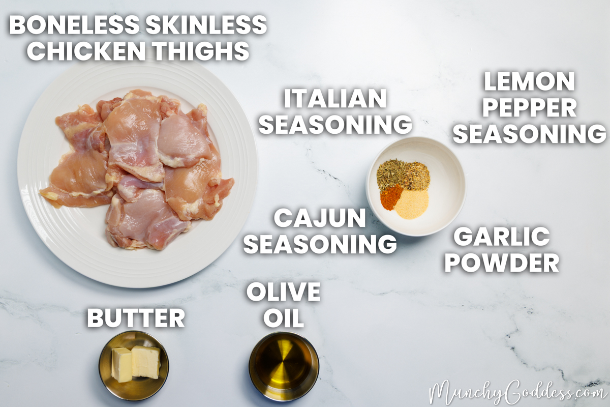 Cajun butter chicken thighs recipe ingredients in various dishes on a white marble surface: boneless skinless chicken thighs, butter, olive oil, Cajun seasoning, Italian seasoning, lemon pepper seasoning, and garlic powder.