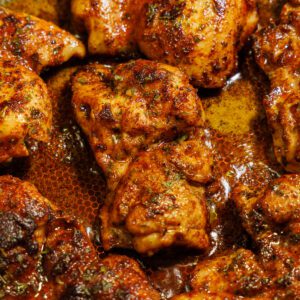 Pan seared chicken thighs in a skillet.