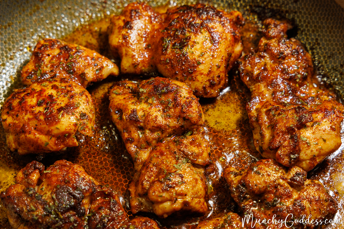 Boneless skinless chicken thighs flipped and cooking smooth side down.