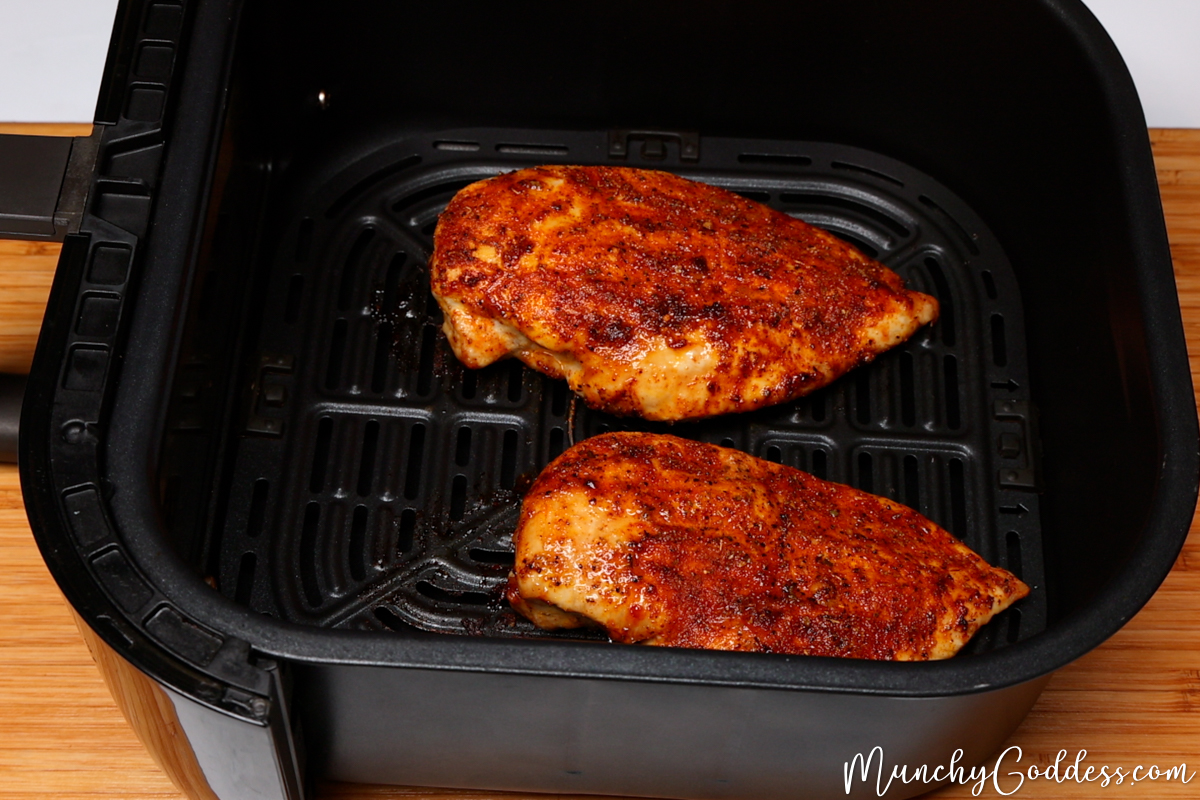 Fully cooked chicken breast in a black air fryer basket.