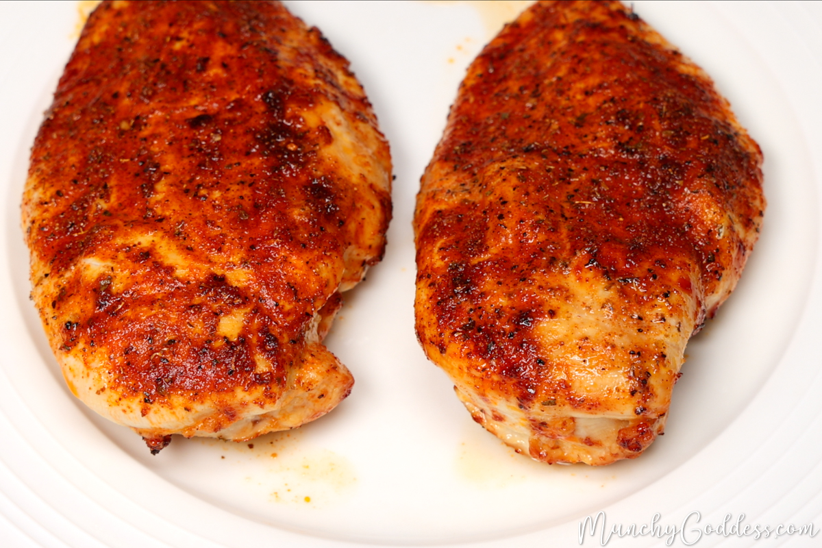 Chicken breast placed on an off-white plate immediately after being cooked in the air fryer.