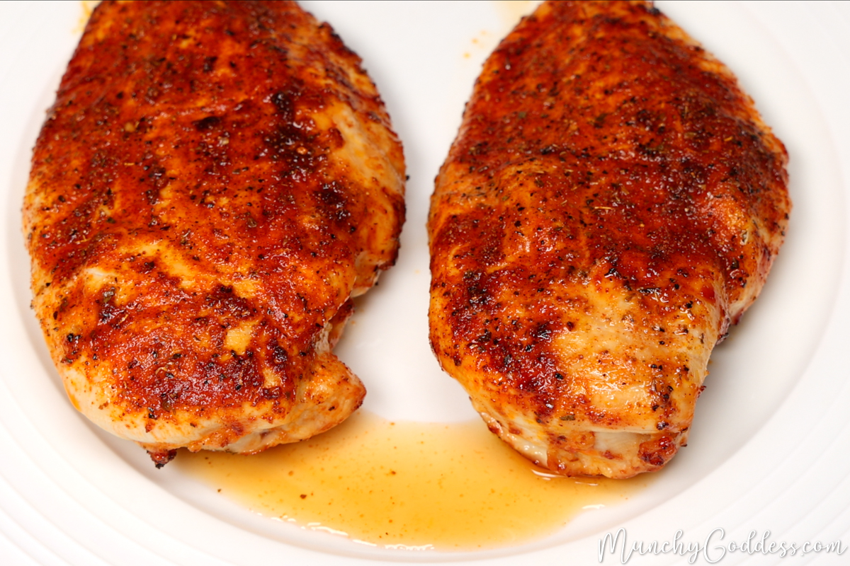 Chicken breast with juices accumulated underneath from resting for 5-10 minutes after being cooked.