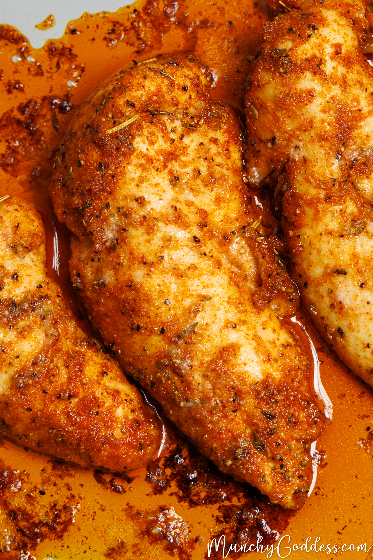 Juicy baked chicken tenderloins seasoned to perfection side by side in a baking dish.