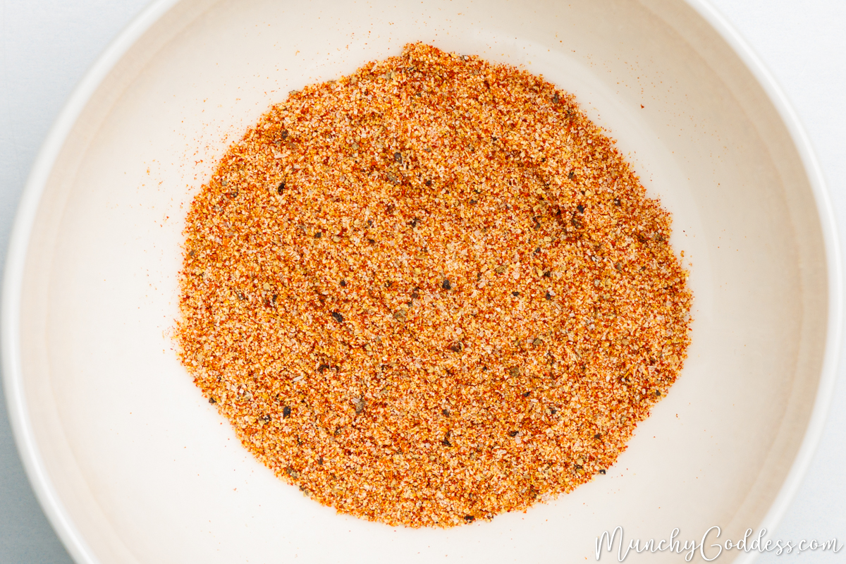 Salt, ground black pepper, smoked paprika, ground cumin, garlic powder, and onion powder blended in an off-white bowl.