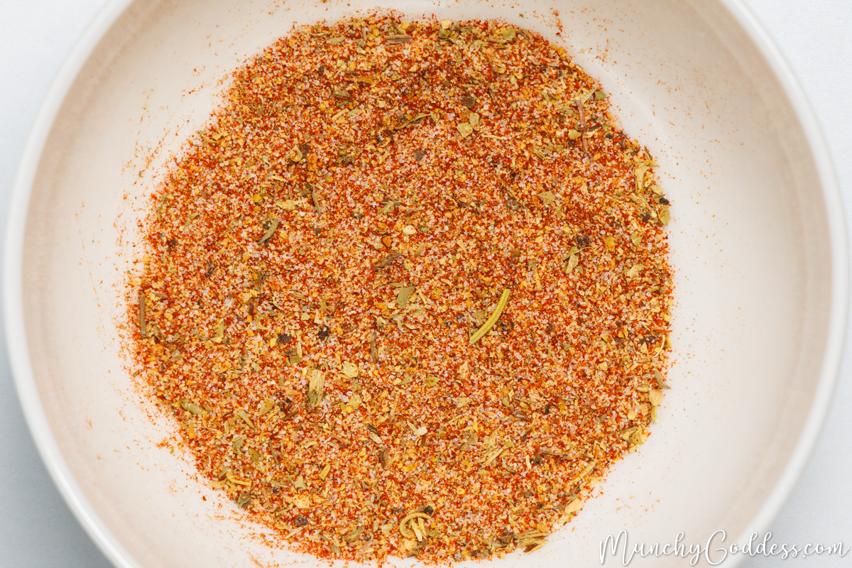 Smoked paprika, salt, garlic powder, Italian seasoning, and lemon pepper seasoning blended in an off-white bowl.