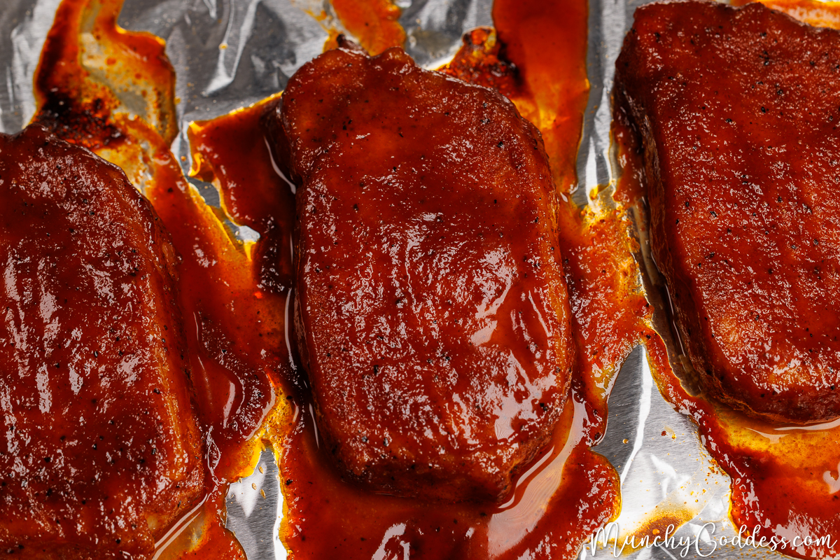 Baked bbq boneless pork chops on foil.
