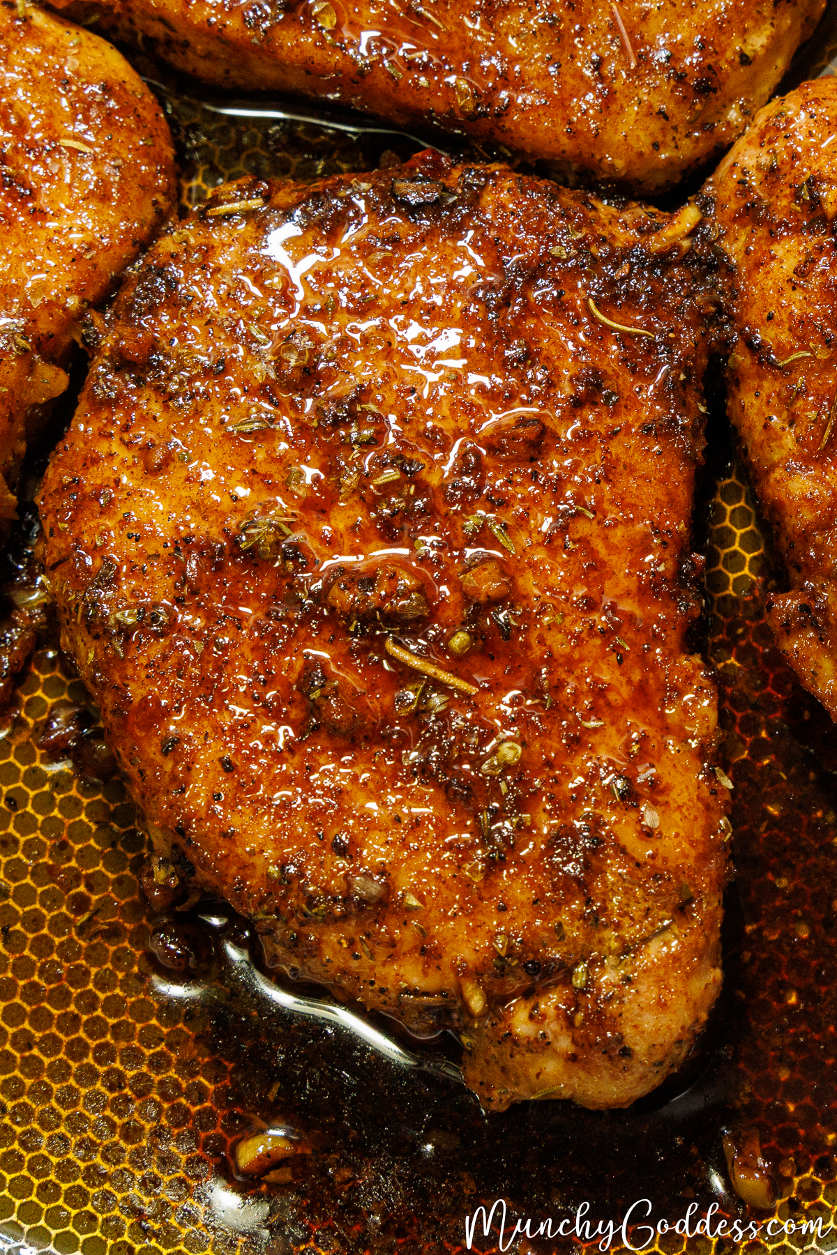 A perfectly seared, juicy pork chop glistening with garlic butter and herbs.