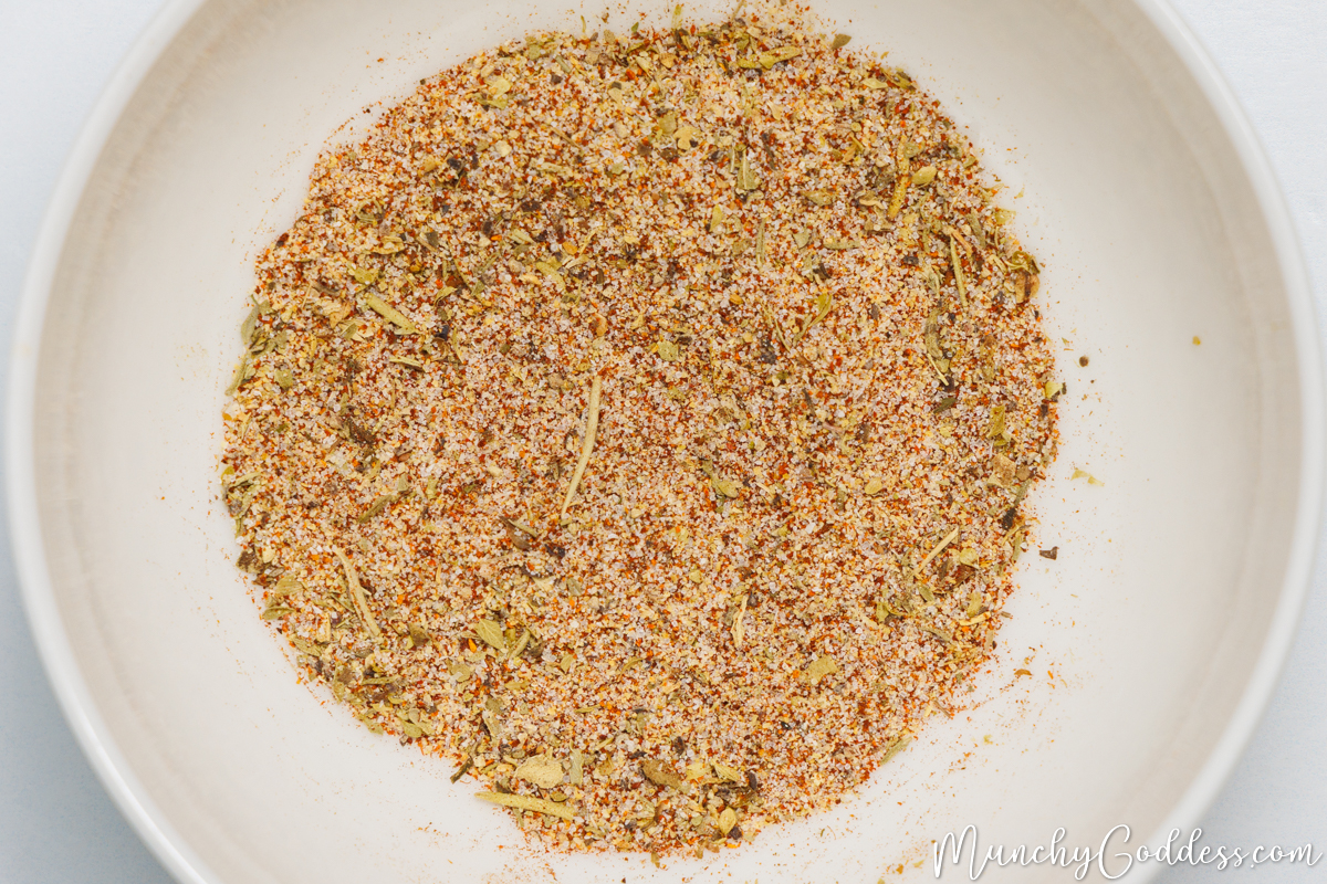 Italian seasoning, garlic powder, ground black pepper, salt, onion powder, and smoked paprika blended in an off-white bowl.